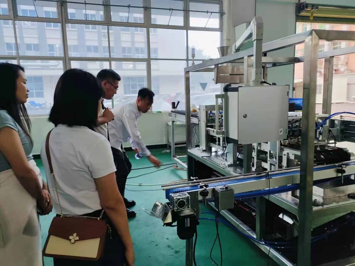 Ken is explaining Saneu's filling machine to customers
