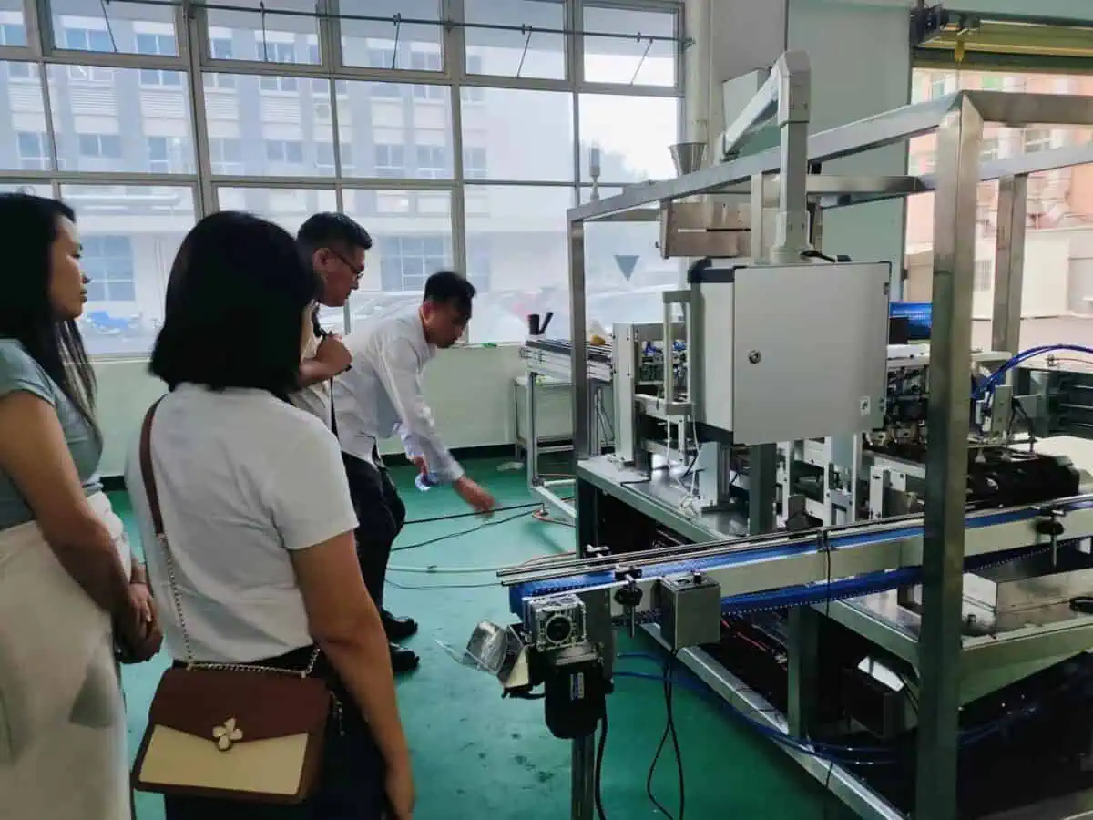 Ken is explaining Saneu's filling machine to customers